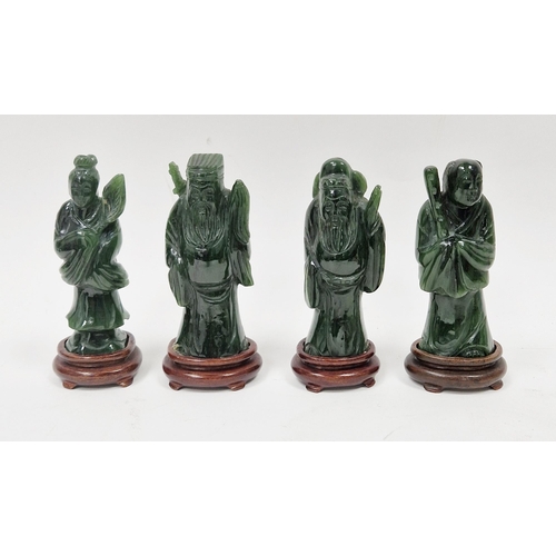 113 - Set of four Chinese carved spinach jade immortals, each on integral wood stand, 12.5cm high (4)