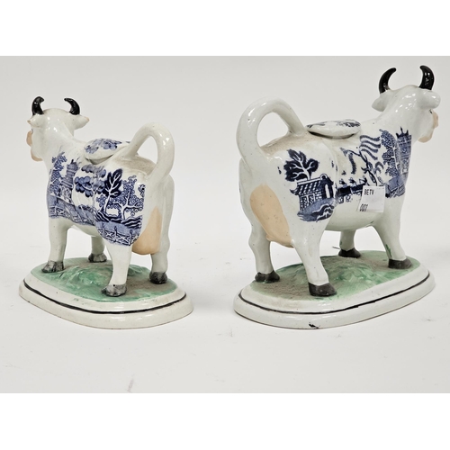 55 - Two 19th century Staffordshire pottery cow creamers with blue transfer willow pattern standing on gr... 