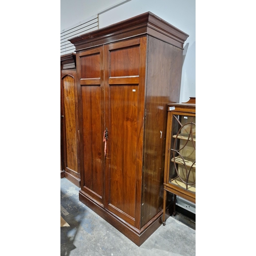 1038 - Large late Victorian mahogany two-door wardrobe containing a clothes rail and numerous coat hooks, 2... 