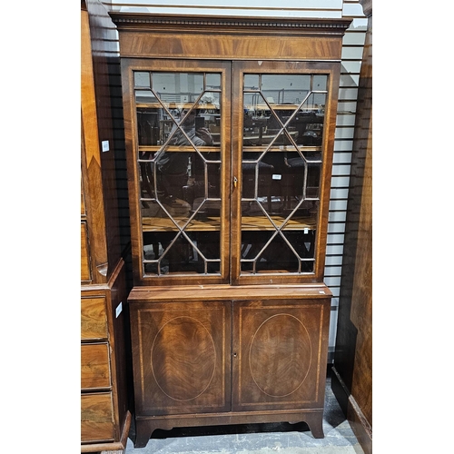 1042 - 20th century mahogany and cross-banded library bookcase in the Georgian manner, the upper section wi... 