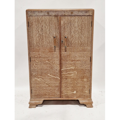 1053 - 1930's / 1940's limed oak bachelor's wardrobe, the two panel doors opening to a hanging space and fo... 