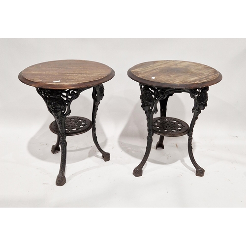 1055 - Pair of Victorian style cast iron pub tables, the circular hardwood tops raised on black finished  t... 