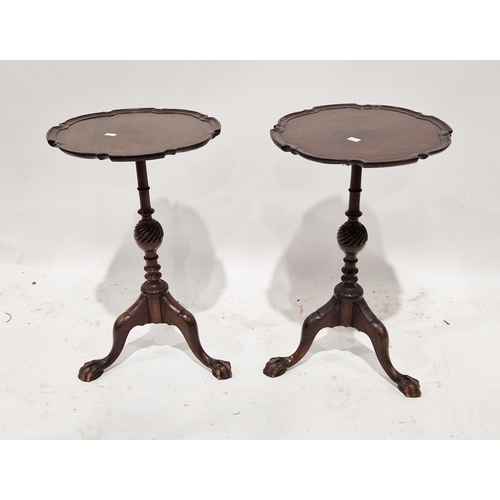 1060 - A pair of mahogany lamp or wine tables in the George III manner the circular tops with shaped moulde... 