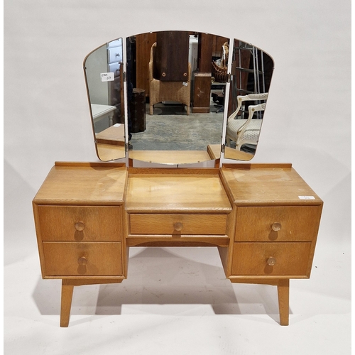 1064 - Meredew mid 20th century oak kneehole dressing table with frameless triple folding mirror, five shor... 