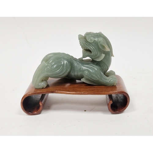 112 - Chinese carved celadon green jade model of a dragon, 5.5cm x 8.5cm and the hardwood stand