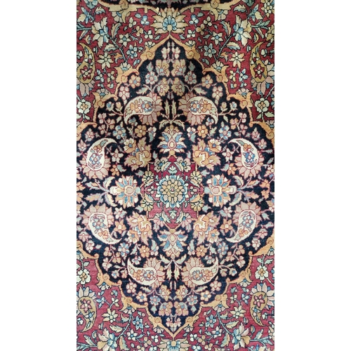 1212 - Eastern wool rug of Persian design, having black arabesque to the cherry red field with allover flor... 