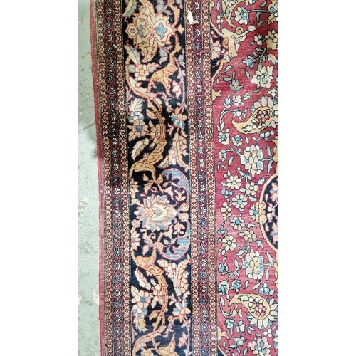 1212 - Eastern wool rug of Persian design, having black arabesque to the cherry red field with allover flor... 