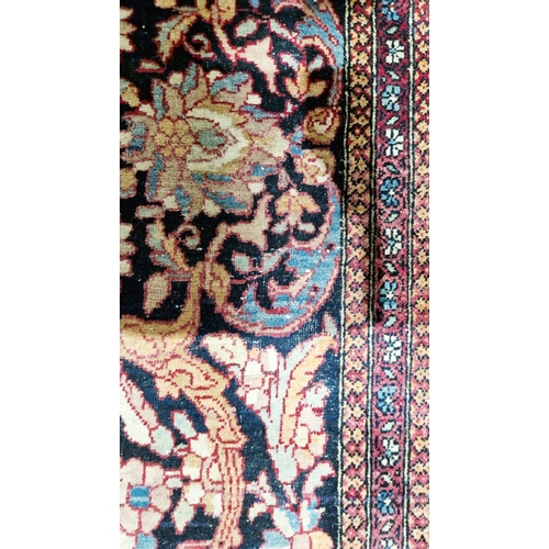 1212 - Eastern wool rug of Persian design, having black arabesque to the cherry red field with allover flor... 