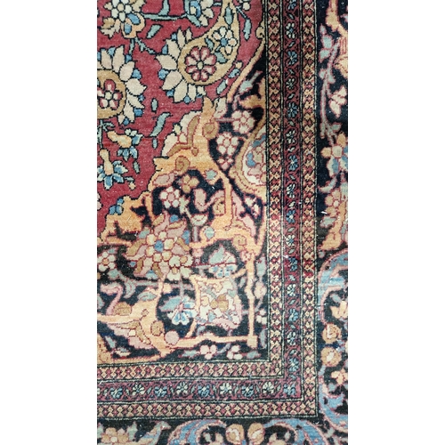 1212 - Eastern wool rug of Persian design, having black arabesque to the cherry red field with allover flor... 