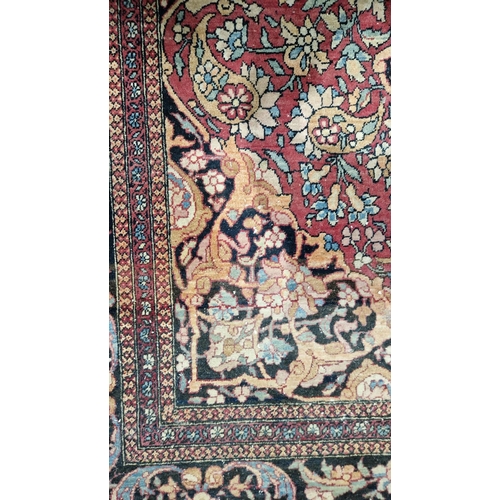 1212 - Eastern wool rug of Persian design, having black arabesque to the cherry red field with allover flor... 