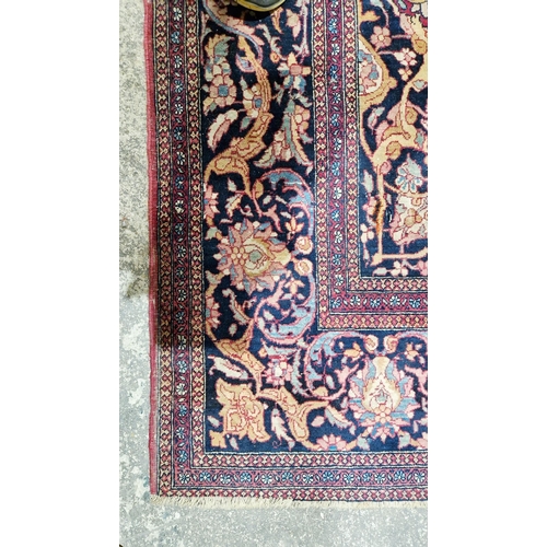 1212 - Eastern wool rug of Persian design, having black arabesque to the cherry red field with allover flor... 