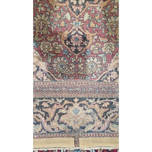 1212 - Eastern wool rug of Persian design, having black arabesque to the cherry red field with allover flor... 