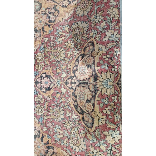 1212 - Eastern wool rug of Persian design, having black arabesque to the cherry red field with allover flor... 