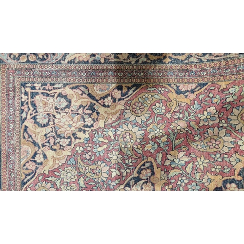 1212 - Eastern wool rug of Persian design, having black arabesque to the cherry red field with allover flor... 