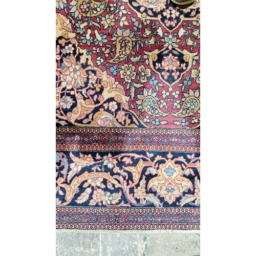 1212 - Eastern wool rug of Persian design, having black arabesque to the cherry red field with allover flor... 