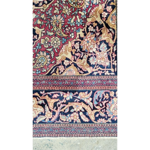 1212 - Eastern wool rug of Persian design, having black arabesque to the cherry red field with allover flor... 