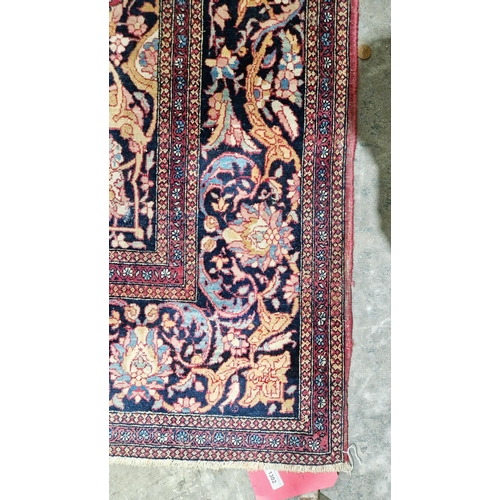 1212 - Eastern wool rug of Persian design, having black arabesque to the cherry red field with allover flor... 