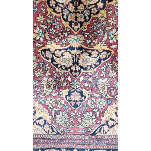 1212 - Eastern wool rug of Persian design, having black arabesque to the cherry red field with allover flor... 