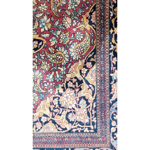 1212 - Eastern wool rug of Persian design, having black arabesque to the cherry red field with allover flor... 