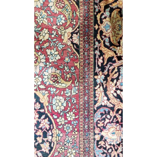 1212 - Eastern wool rug of Persian design, having black arabesque to the cherry red field with allover flor... 