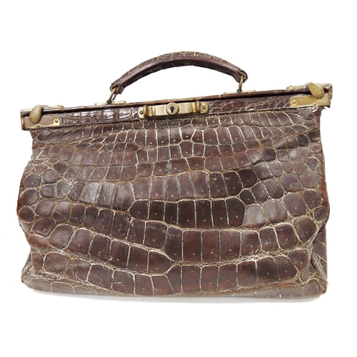 148 - Late 19th/early 20th century crocodile skin gladstone bag with brass fittings and mustard coloured w... 