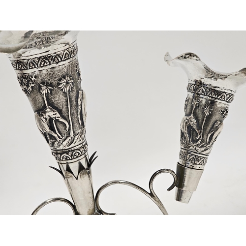 314 - Indian colonial white metal epergne, stamped with maker's mark, the three trumpets with repousse dec... 