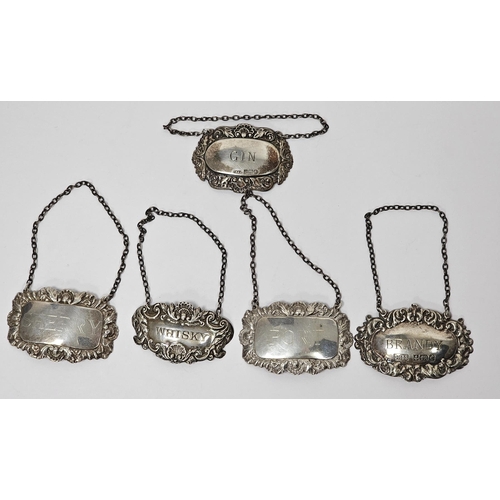 390 - Collection of five silver spirit decanter labels, all with repousse foliate and scrolling decoration... 