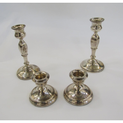 446 - Pair of 1920's silver candlesticks, each with waisted sconce, panel tapering column on circular foot... 