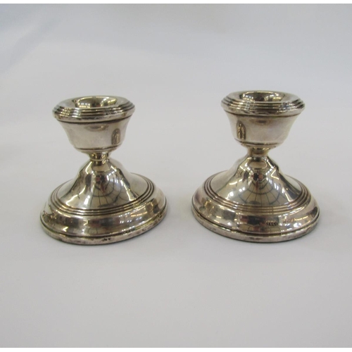 446 - Pair of 1920's silver candlesticks, each with waisted sconce, panel tapering column on circular foot... 