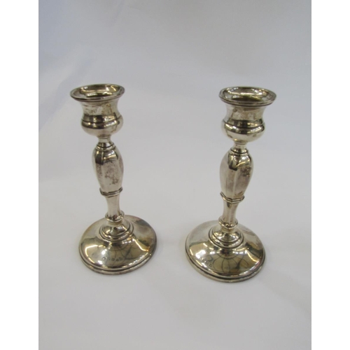 446 - Pair of 1920's silver candlesticks, each with waisted sconce, panel tapering column on circular foot... 