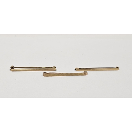 579 - Two 9ct gold plain tie bars and another 9ct gold tie bar with engine turned decoration 6.9g total ap... 