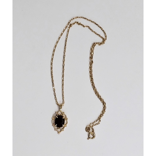 581 - 9ct gold and garnet pendant oval stone in pierced work mount on 9 carat gold oval link chain