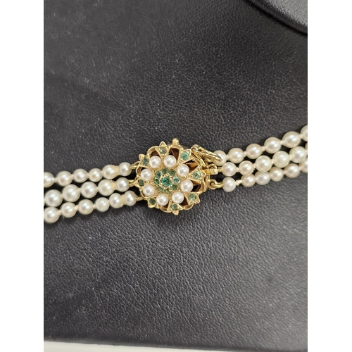 587 - Triple string of graduated pearls with 9ct gold emerald and pearl clasp flat head design