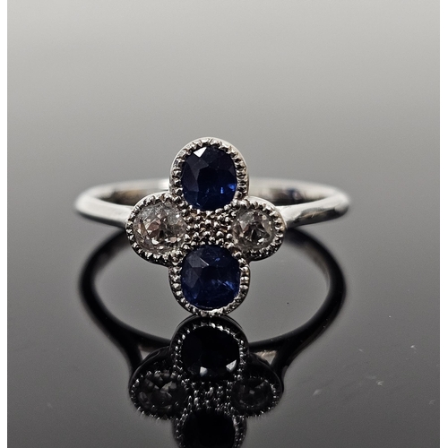 630 - 18ct white gold diamond and sapphire quatrefoil flowerhead cluster ring, with two cut sapphire and t... 