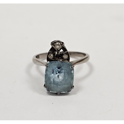 683 - White metal and pale blue stone solitaire ring, the cushion shape stone topped by a trio of three ti... 