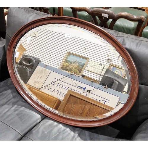 1264 - Early 20th century mahogany-framed oval mirror with a bevelled edge