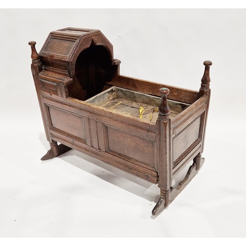 1104 - 17th/18th century joined oak rocking cradle with hinged fold back hood, four turned finials and pane... 