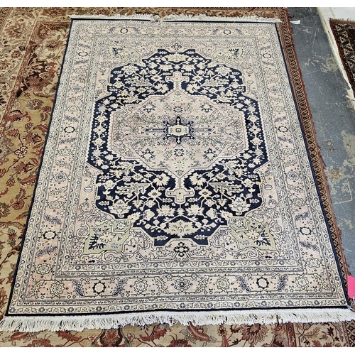 1268 - Large Persian style cream ground rug with central geometric and floral medallion on a midnight blue ... 