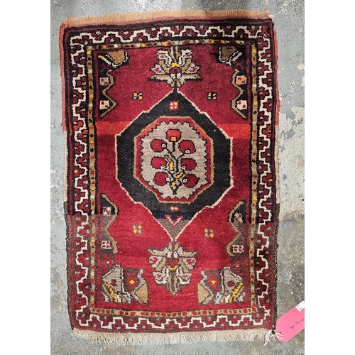 1273 - Eastern red ground rug with three central lozenge medallions flanked by two rows of four elephant fo... 