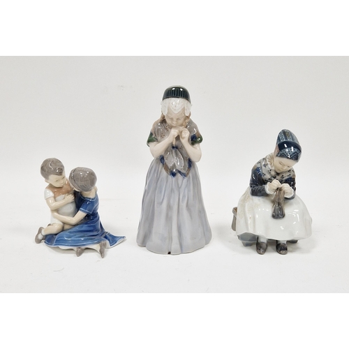 27 - Three Danish porcelain figures, comprising: a Bing & Grondahl boy and girl in an embrace, a Royal Co... 