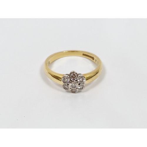 484 - 18ct gold and diamond flowerhead ring, the seven stones in rubover settings (size N)