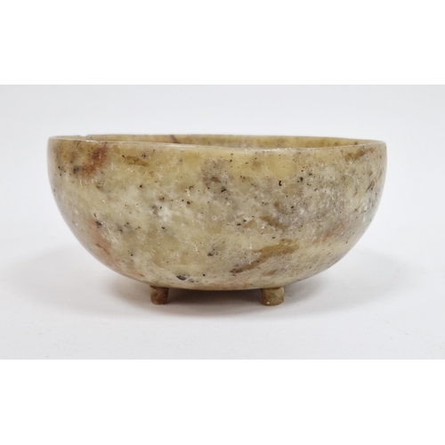 101 - Chinese soapstone bowl, of cup-form, raised on four stilt feet, on wooden stand 13cm diam.