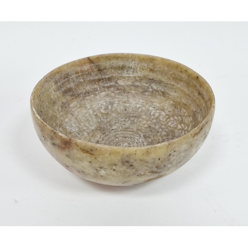 101 - Chinese soapstone bowl, of cup-form, raised on four stilt feet, on wooden stand 13cm diam.