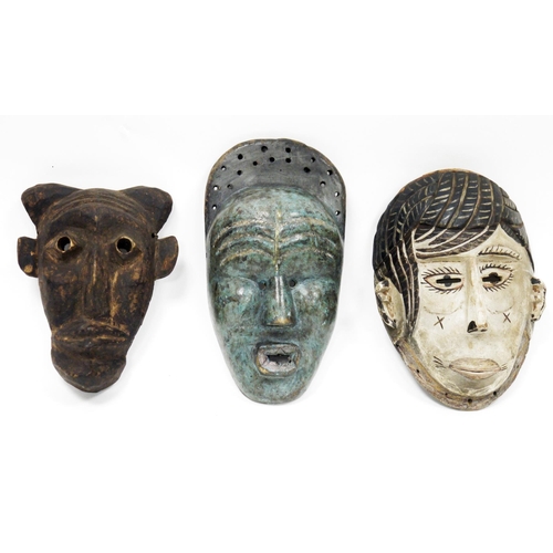 124 - Three ethnic wooden carved face masks, one with mottled blue finish and another with a white finish,... 