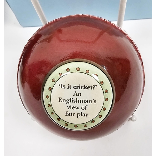 172 - Halcyon Days porcelain and enamel bonbonniere in the form of a cricket ball, inscribed 'Is It Cricke... 