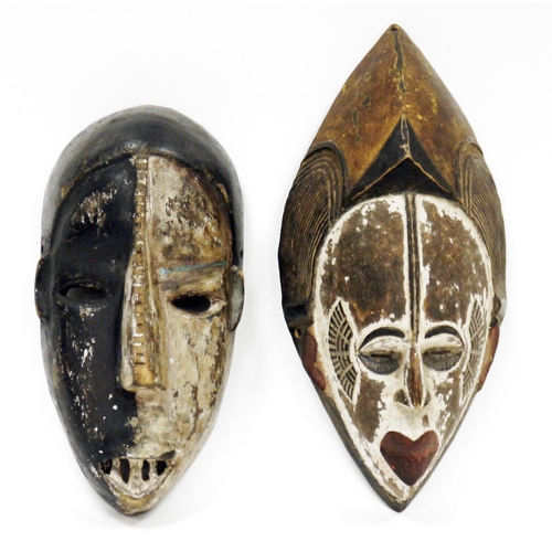 121 - Two ethnic carved wooden face masks, one with half white painted face, possibly Democratic Republic ... 