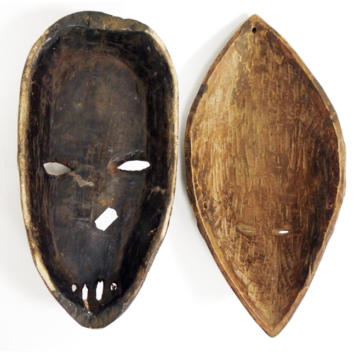 121 - Two ethnic carved wooden face masks, one with half white painted face, possibly Democratic Republic ... 