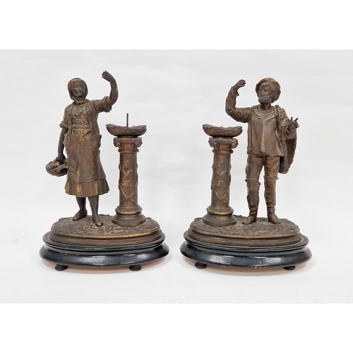 130 - Pair of 19th century spelter figures of a fishmonger and his wife, both with baskets of fish held on... 