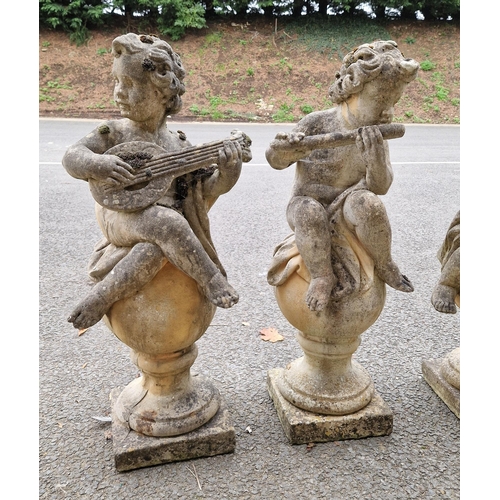 1351 - Set of four composite stone garden statues in the form of musical putti playing tambourine, mandolin... 