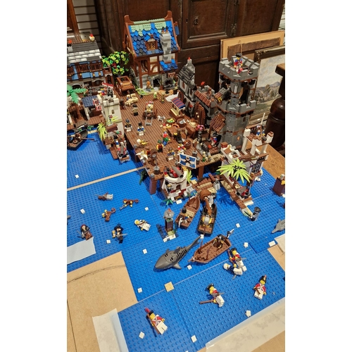755 - A large Lego Pirate Town diorama featuring several Lego sets to include No.4194 4194 Whitecap Bay, N... 